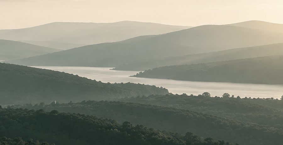 Misty hills above a lake at dawn
